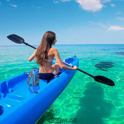 Junge Frau in Bikini paddelt im blauen Kajak mit Celly Explorer Dry Bag 2L